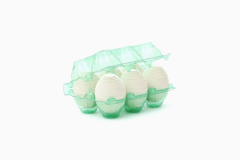 Limited edition print of six layered white cardboard eggs in a clear green plastic six-egg carton